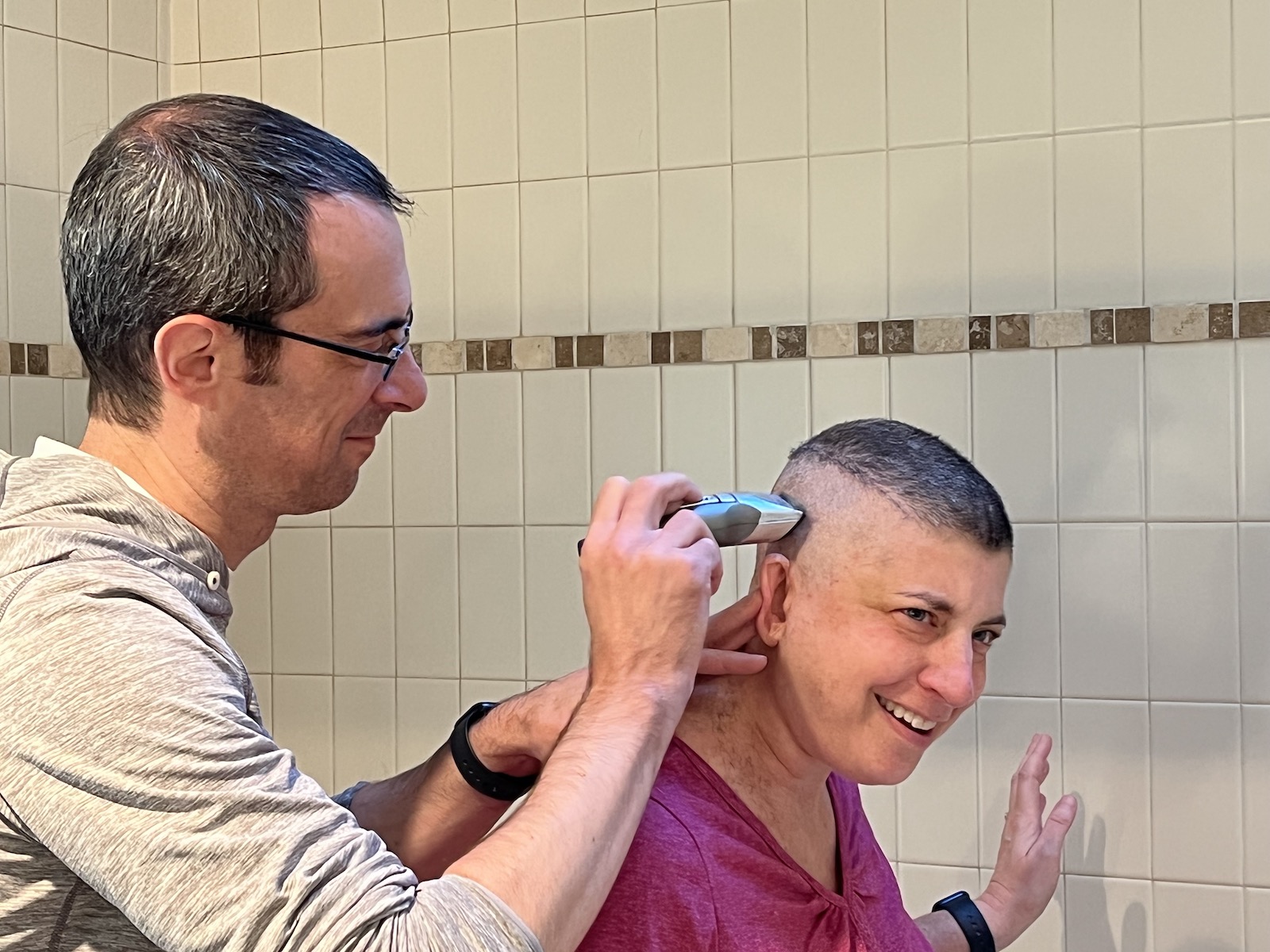 Aaron using clippers on Lisa's remaining hair